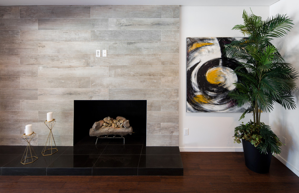 ロサンゼルスにある広いコンテンポラリースタイルのおしゃれなLDK (白い壁、濃色無垢フローリング、標準型暖炉、タイルの暖炉まわり、テレビなし、茶色い床) の写真