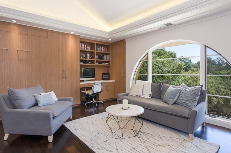 Diseño de sala de estar con biblioteca tipo loft contemporánea grande sin chimenea con paredes blancas, suelo de madera oscura y televisor retractable