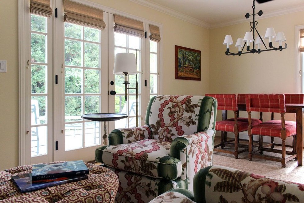 Foto de sala de estar abierta tradicional pequeña con paredes amarillas, suelo de madera en tonos medios, chimenea de esquina, marco de chimenea de madera, televisor colgado en la pared y suelo marrón