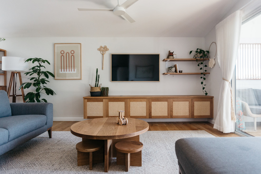 Пример оригинального дизайна: гостиная комната среднего размера в морском стиле с белыми стенами, светлым паркетным полом и телевизором на стене без камина