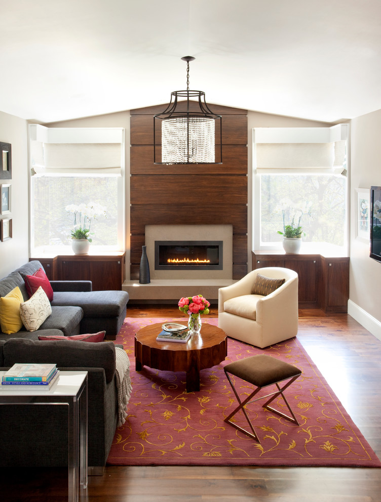 Ejemplo de sala de estar contemporánea grande con paredes grises, suelo de madera oscura, chimenea lineal, marco de chimenea de madera y suelo gris