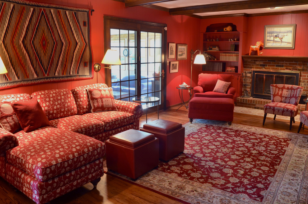 Family room - mid-sized contemporary enclosed medium tone wood floor family room idea in Columbus with red walls, a standard fireplace, a brick fireplace and a tv stand