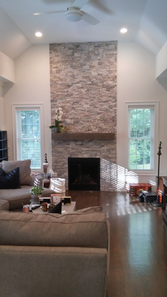 Ejemplo de sala de estar tradicional renovada extra grande con marco de chimenea de piedra