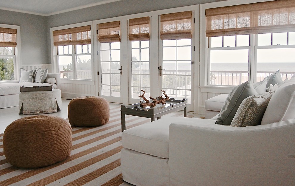 Imagen de sala de estar con biblioteca abierta marinera con paredes azules y suelo de madera pintada