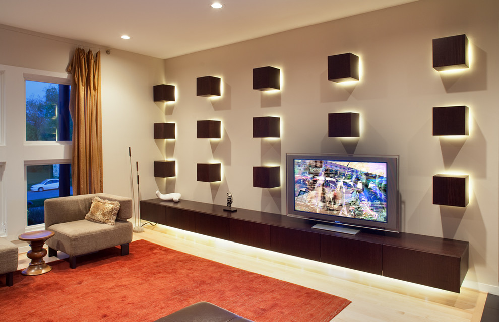 Ejemplo de sala de estar abierta actual de tamaño medio con paredes beige, suelo de madera clara, televisor independiente y alfombra