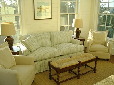 Esempio di un piccolo soggiorno stile marinaro aperto con pareti bianche, pavimento in legno massello medio e TV nascosta