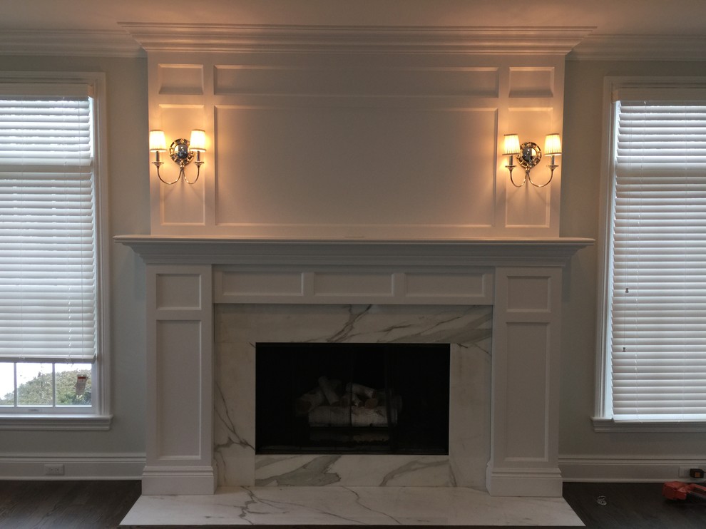 Modelo de sala de estar abierta tradicional renovada grande con suelo de madera en tonos medios, chimenea de doble cara y marco de chimenea de piedra