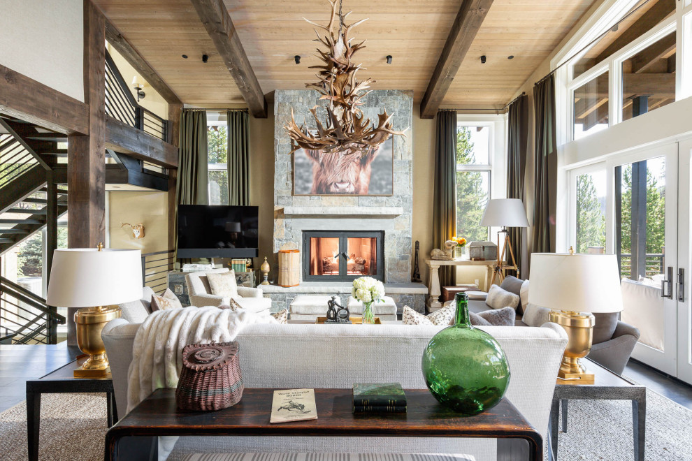 Example of a large mountain style open concept dark wood floor and black floor family room design in Other with beige walls, a standard fireplace, a stone fireplace and a tv stand