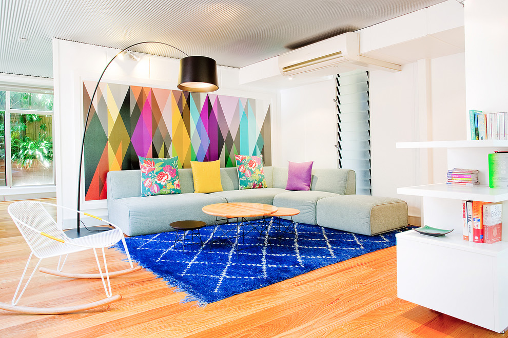 Imagen de sala de estar actual de tamaño medio con paredes blancas y suelo de madera clara