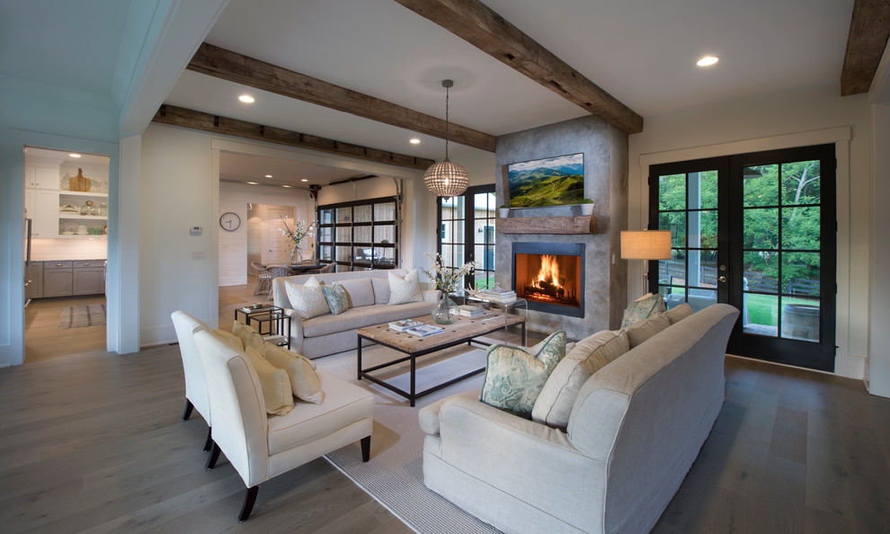 Large farmhouse open plan games room in Atlanta with grey walls, light hardwood flooring, a standard fireplace, a plastered fireplace surround and a wall mounted tv.