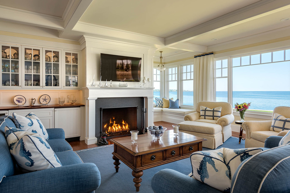 Photo of a medium sized beach style games room in Portland Maine with yellow walls, a standard fireplace, a wall mounted tv and medium hardwood flooring.