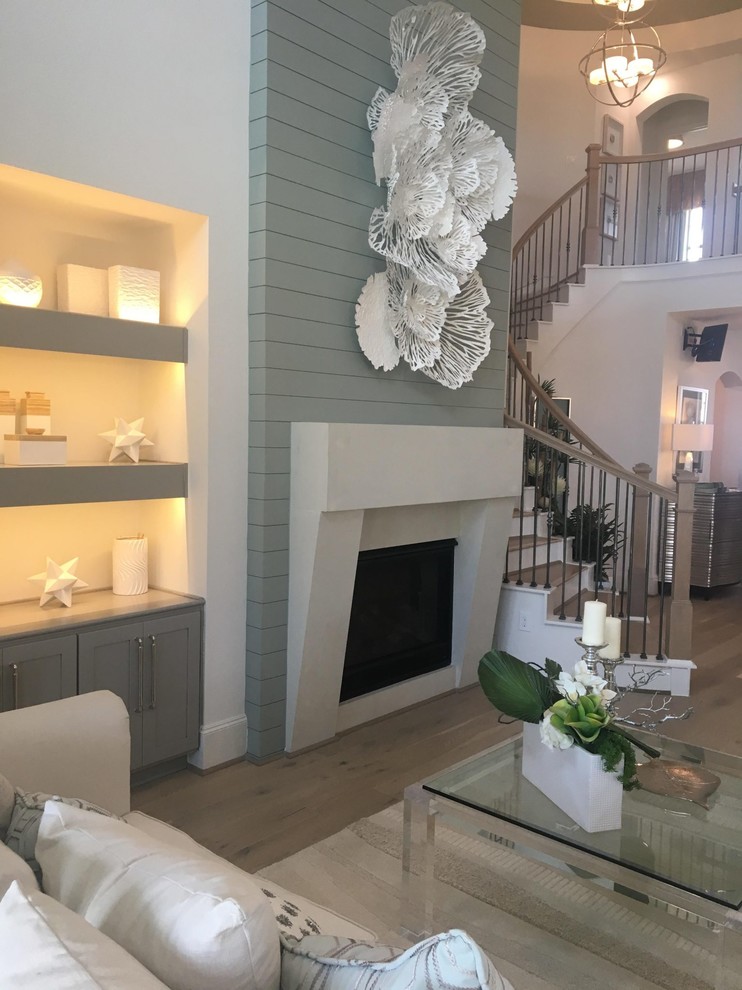 Inspiration for a contemporary games room in Houston with grey walls, light hardwood flooring, a standard fireplace, a concrete fireplace surround, no tv and beige floors.