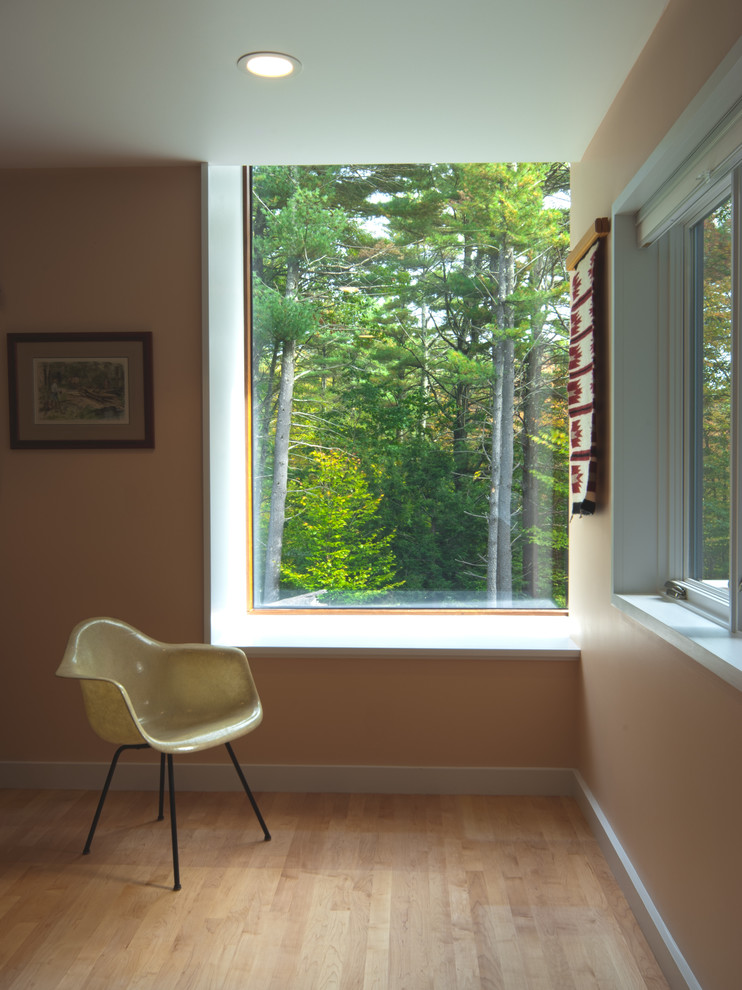 Idée de décoration pour une salle de séjour minimaliste fermée avec un mur orange et parquet clair.