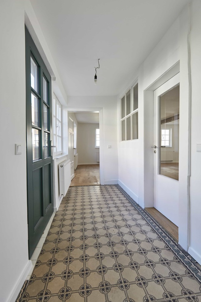 Exemple d'un petit couloir chic avec un mur blanc, un sol en brique et un sol beige.