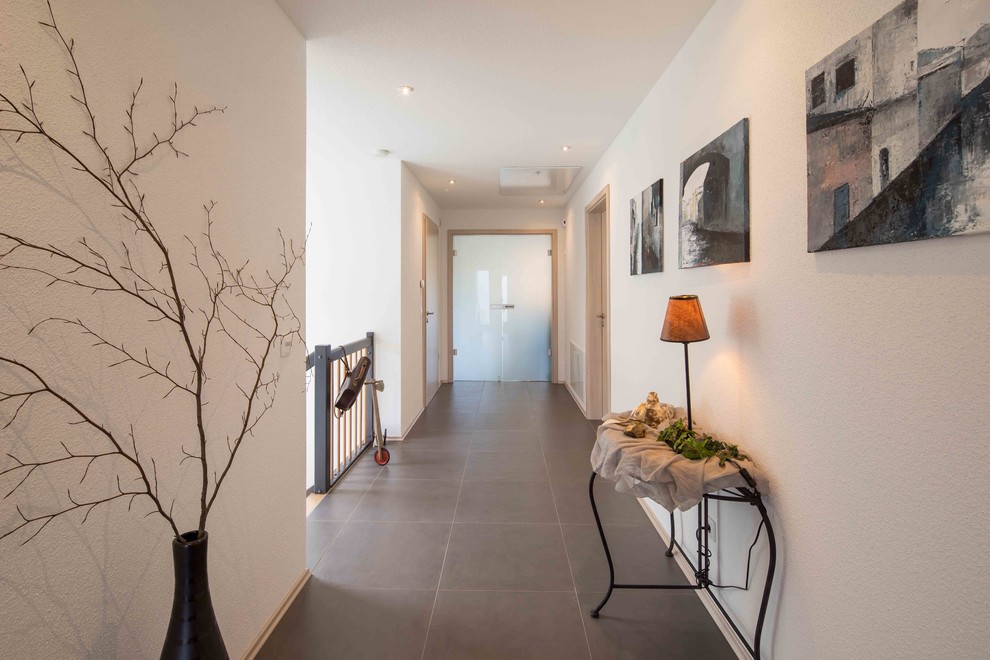 Inspiration för moderna hallar, med vita väggar och grått golv