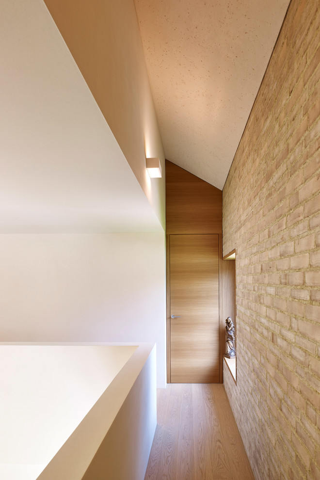 Kleiner Moderner Flur mit bunten Wänden, braunem Holzboden und braunem Boden in Stuttgart