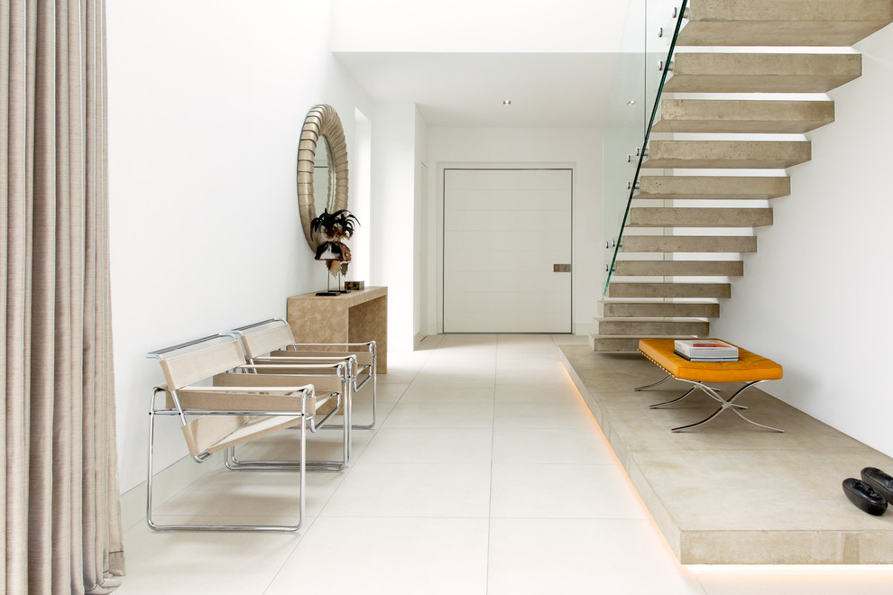 На фото: большой коридор в стиле модернизм с белыми стенами и белым полом с
