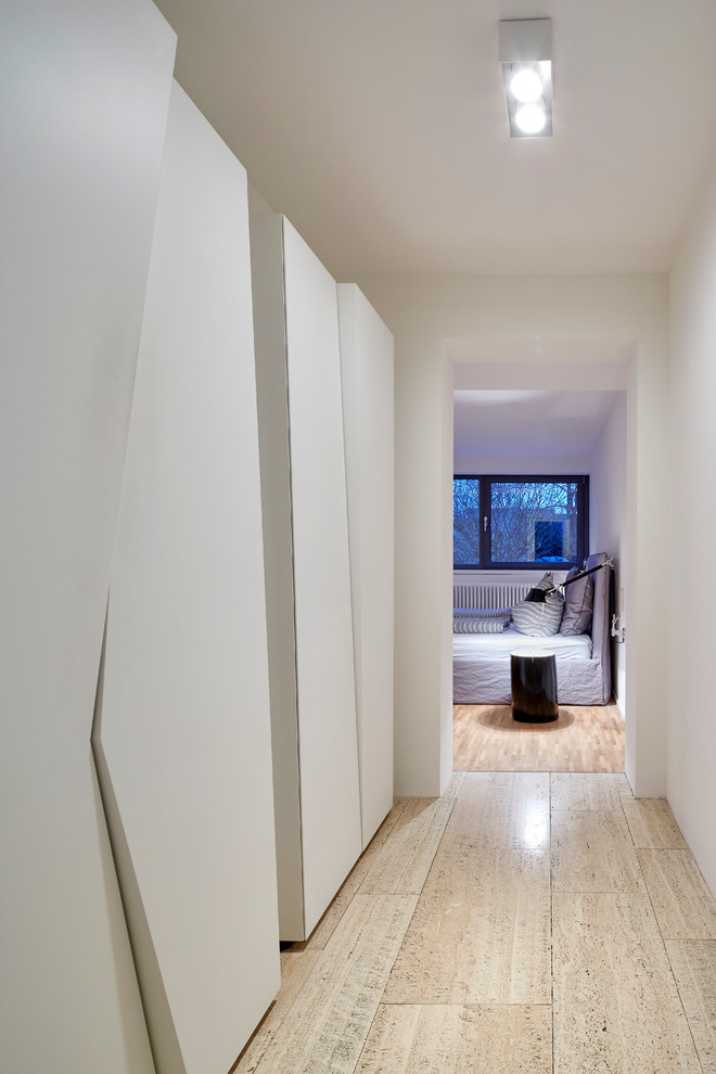 Exemple d'un petit couloir moderne avec un sol en travertin, un mur blanc et un sol beige.
