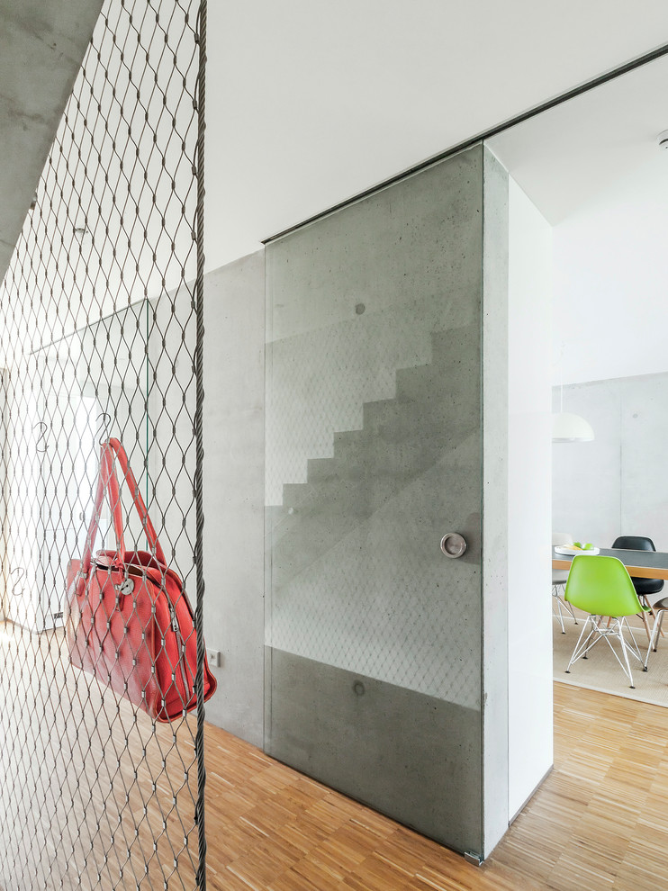 Idee per un piccolo ingresso o corridoio minimal con pareti grigie, pavimento in legno massello medio e pavimento marrone