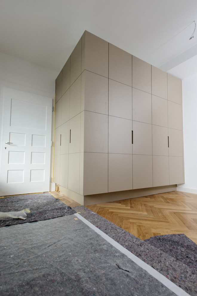 Geräumiger Moderner Flur mit weißer Wandfarbe, dunklem Holzboden und braunem Boden in München