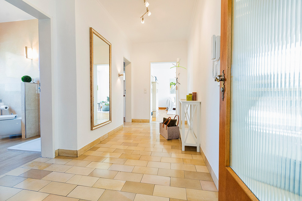 Ispirazione per un ingresso o corridoio minimal di medie dimensioni con pareti bianche e pavimento beige