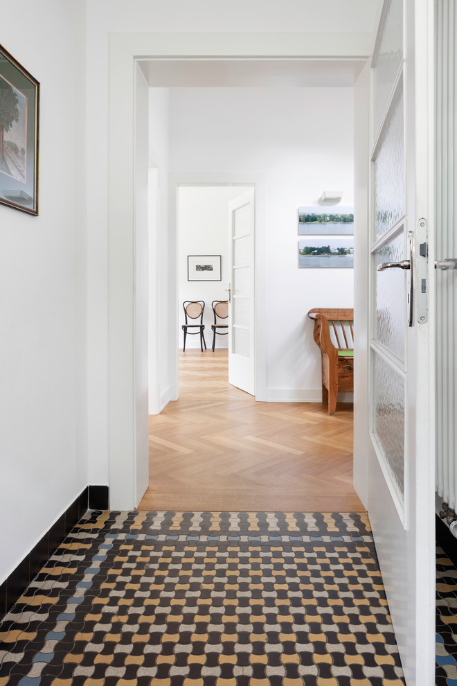 Стильный дизайн: коридор среднего размера в скандинавском стиле с белыми стенами и полом из керамической плитки - последний тренд