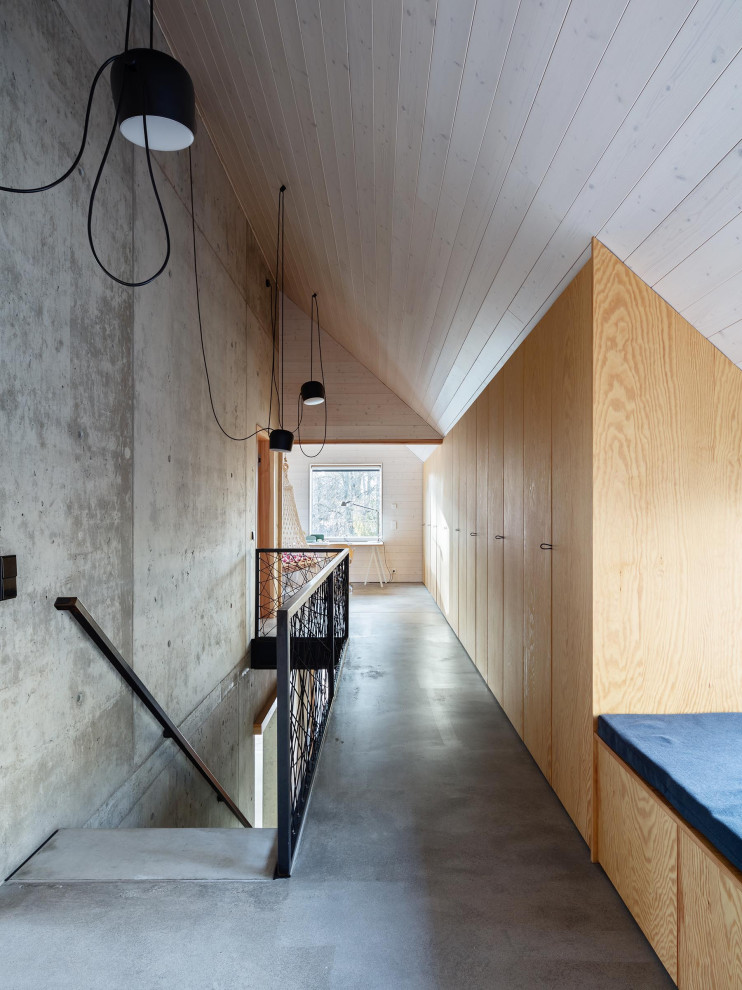 Réalisation d'un très grand couloir nordique en bois avec un mur gris, sol en béton ciré, un sol gris et un plafond en bois.