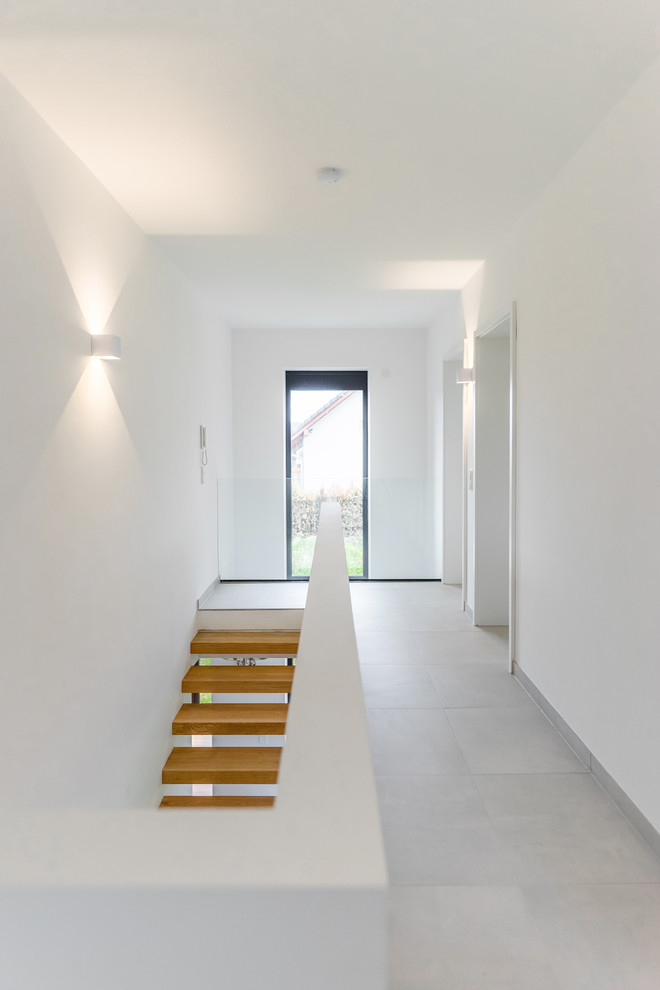 Foto de recibidores y pasillos actuales de tamaño medio con paredes blancas, suelo de baldosas de cerámica y suelo blanco