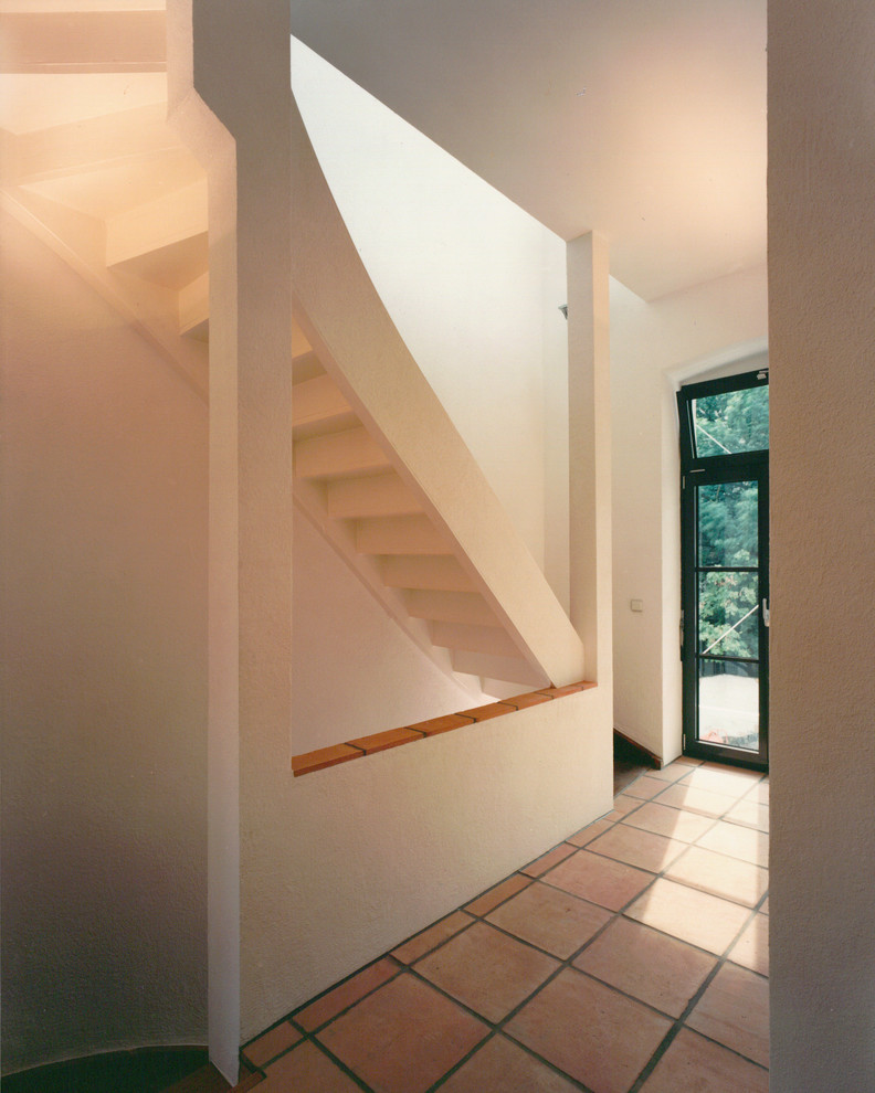 Imagen de recibidores y pasillos actuales con paredes blancas y suelo de baldosas de terracota