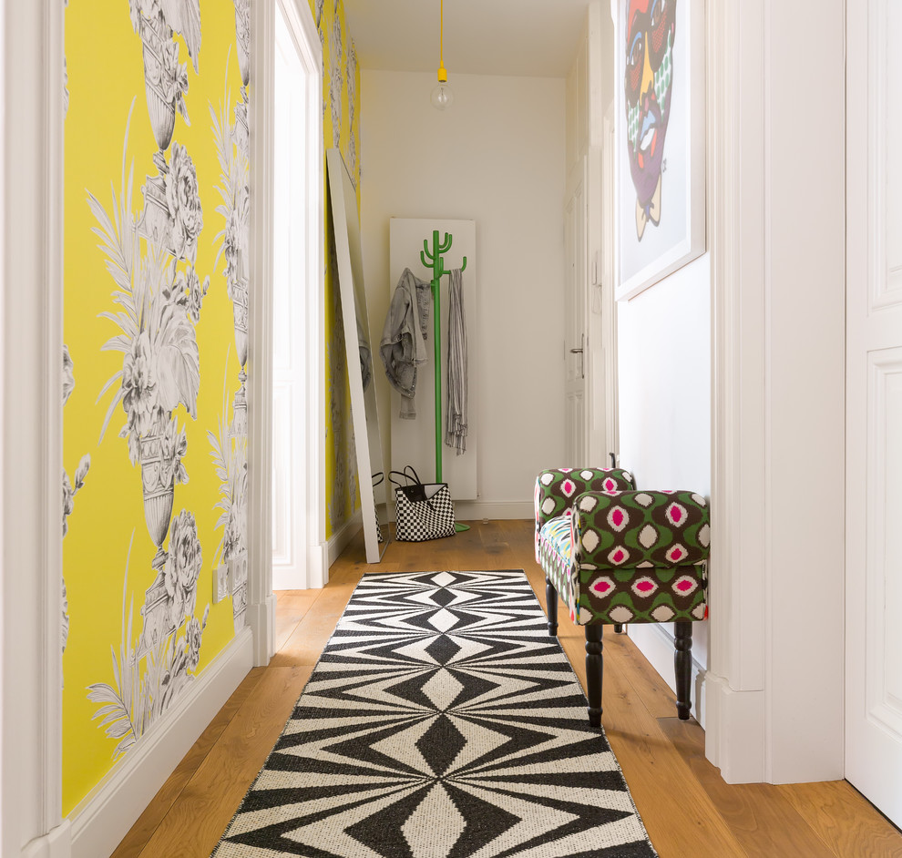 Idées déco pour un petit couloir éclectique avec un mur multicolore et un sol en bois brun.