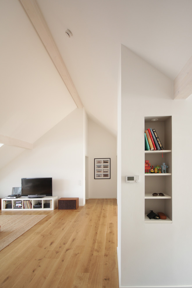 Cette image montre un couloir design de taille moyenne avec un mur blanc et un sol en bois brun.