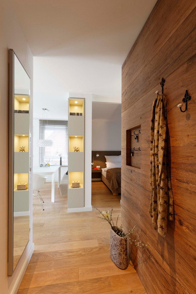 Esempio di un ingresso o corridoio minimal con pareti marroni, pavimento in legno massello medio e pavimento marrone