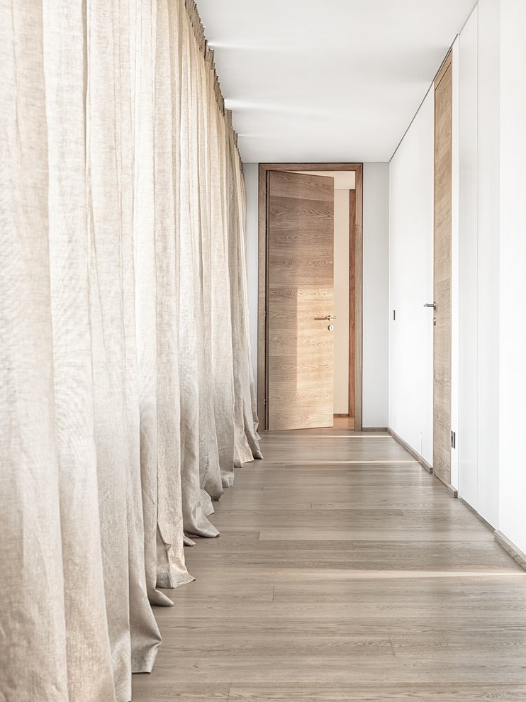 Idée de décoration pour un couloir design avec un mur blanc et un sol en calcaire.
