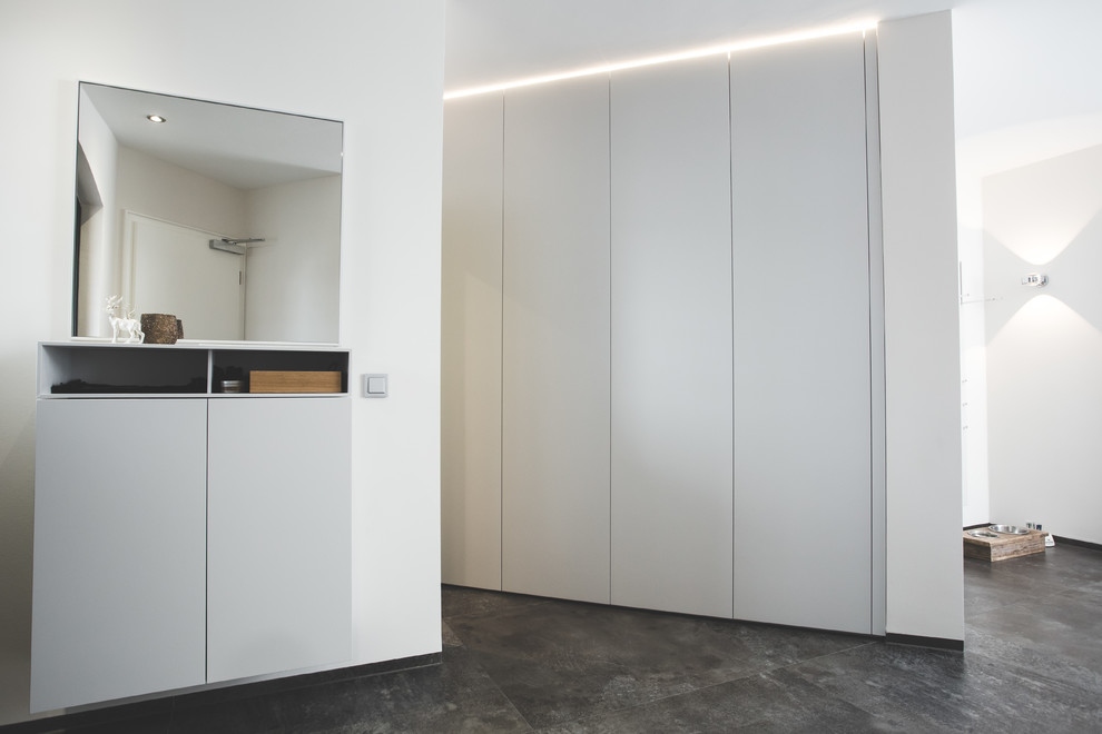 Foto di un piccolo ingresso o corridoio minimalista con pareti bianche, pavimento in ardesia e pavimento grigio