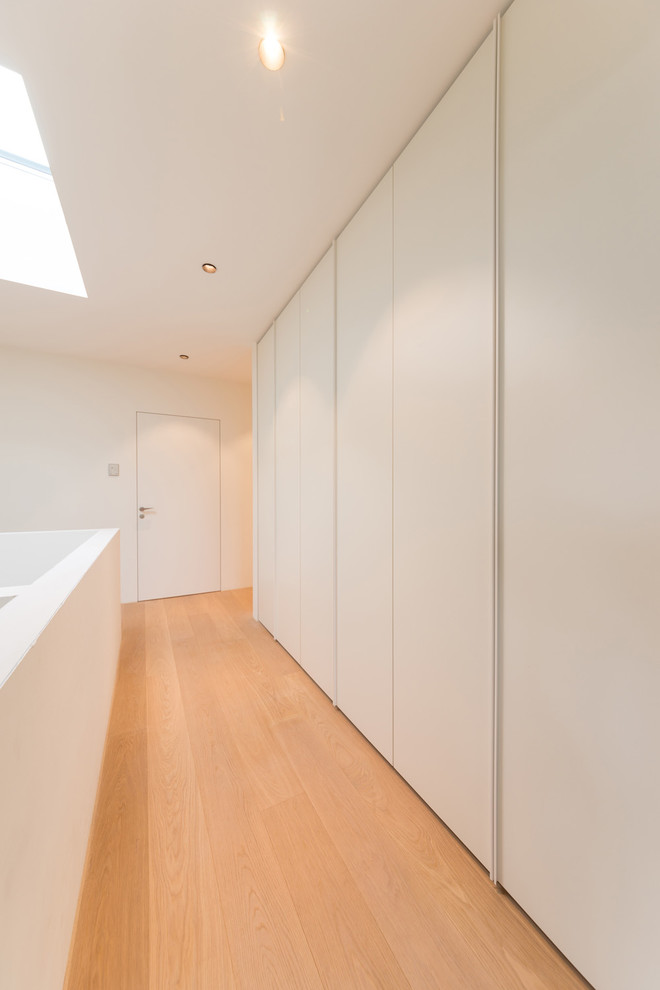 Свежая идея для дизайна: коридор среднего размера в современном стиле с белыми стенами, паркетным полом среднего тона и коричневым полом - отличное фото интерьера