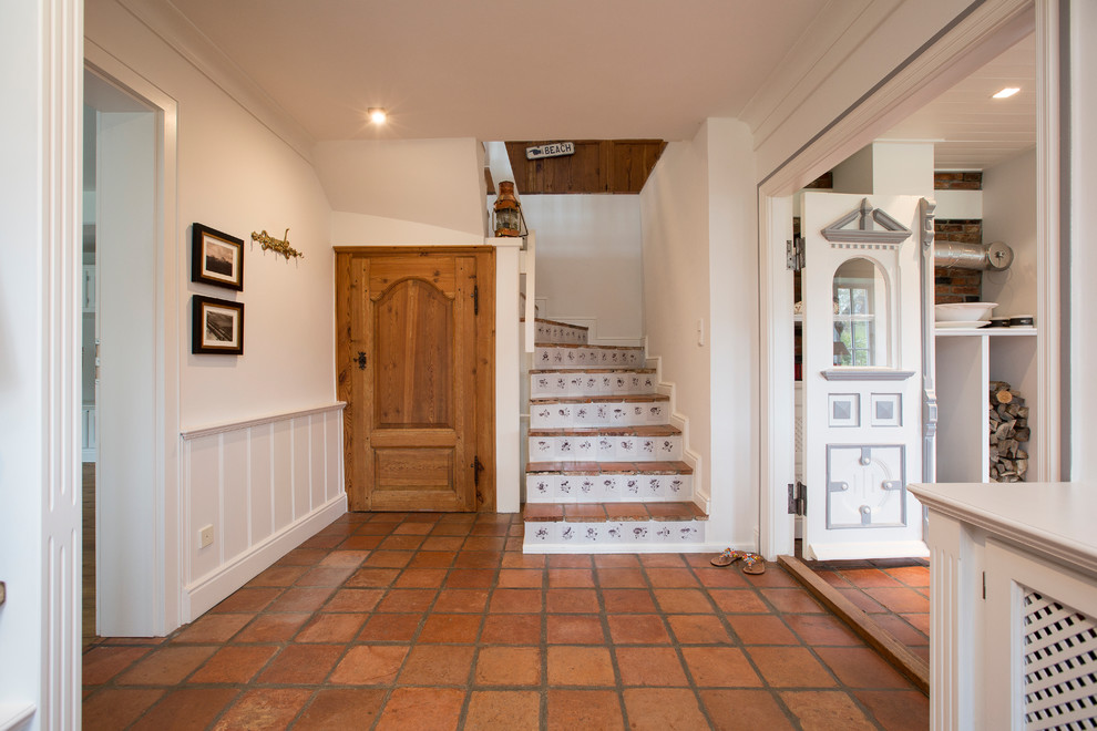 Large cottage terra-cotta tile hallway photo in Other with white walls