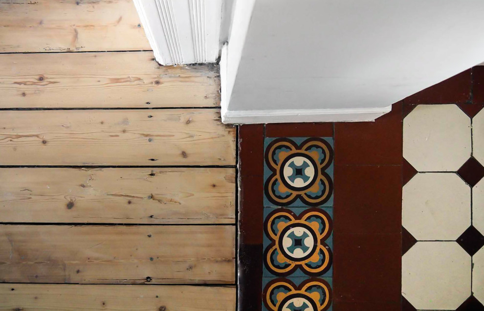 中くらいなトラディショナルスタイルのおしゃれな廊下 (グレーの壁、セラミックタイルの床、赤い床) の写真