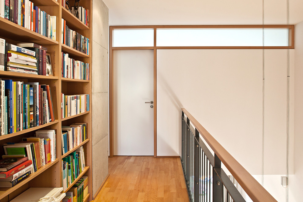 Cette image montre un petit couloir design avec un mur blanc et parquet clair.