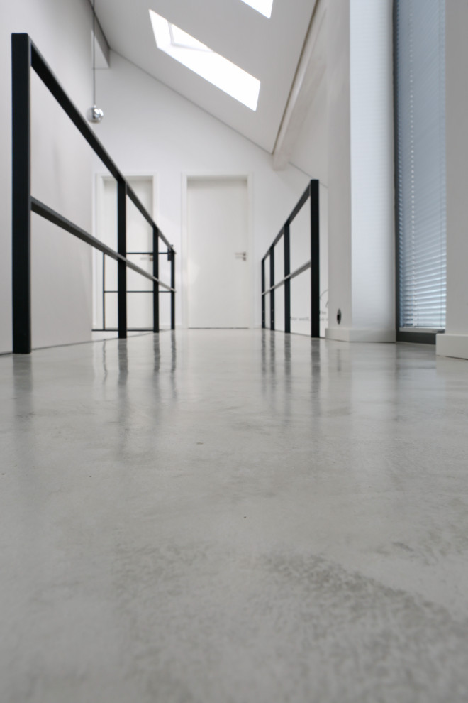 Ispirazione per un ampio ingresso o corridoio minimalista con pavimento in cemento e pavimento grigio