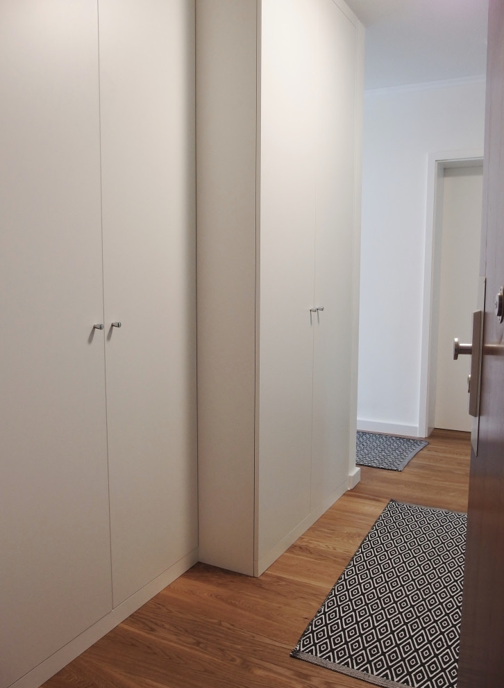 Réalisation d'un petit couloir design avec un mur blanc et parquet clair.