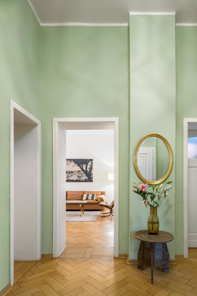 Modelo de recibidores y pasillos retro de tamaño medio con paredes verdes, suelo de madera clara y suelo marrón
