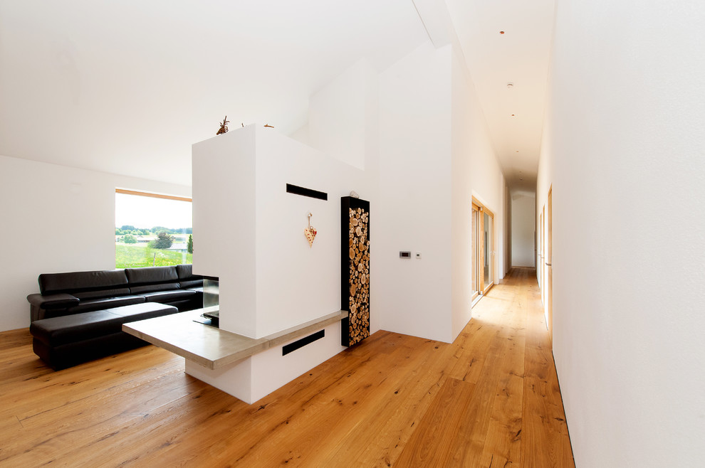 Großer Moderner Flur mit weißer Wandfarbe, braunem Holzboden und braunem Boden in München