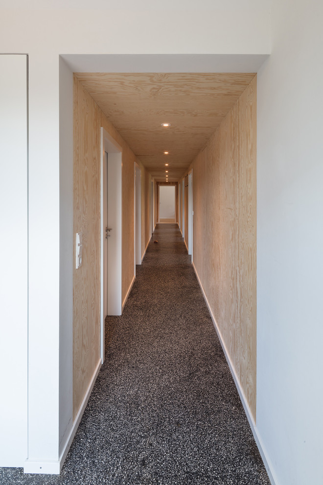 Hallway - large scandinavian terrazzo floor and black floor hallway idea in Hamburg with brown walls