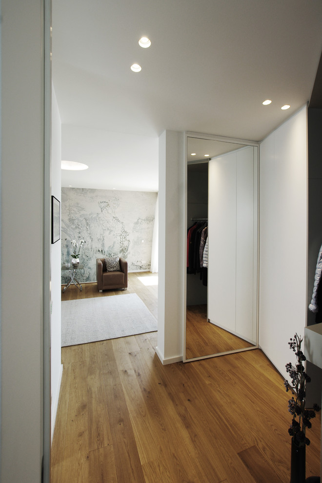 Immagine di un ingresso o corridoio design di medie dimensioni con pareti bianche e pavimento in legno massello medio