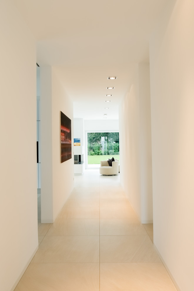 Immagine di un grande ingresso o corridoio minimal con pareti bianche e pavimento con piastrelle in ceramica