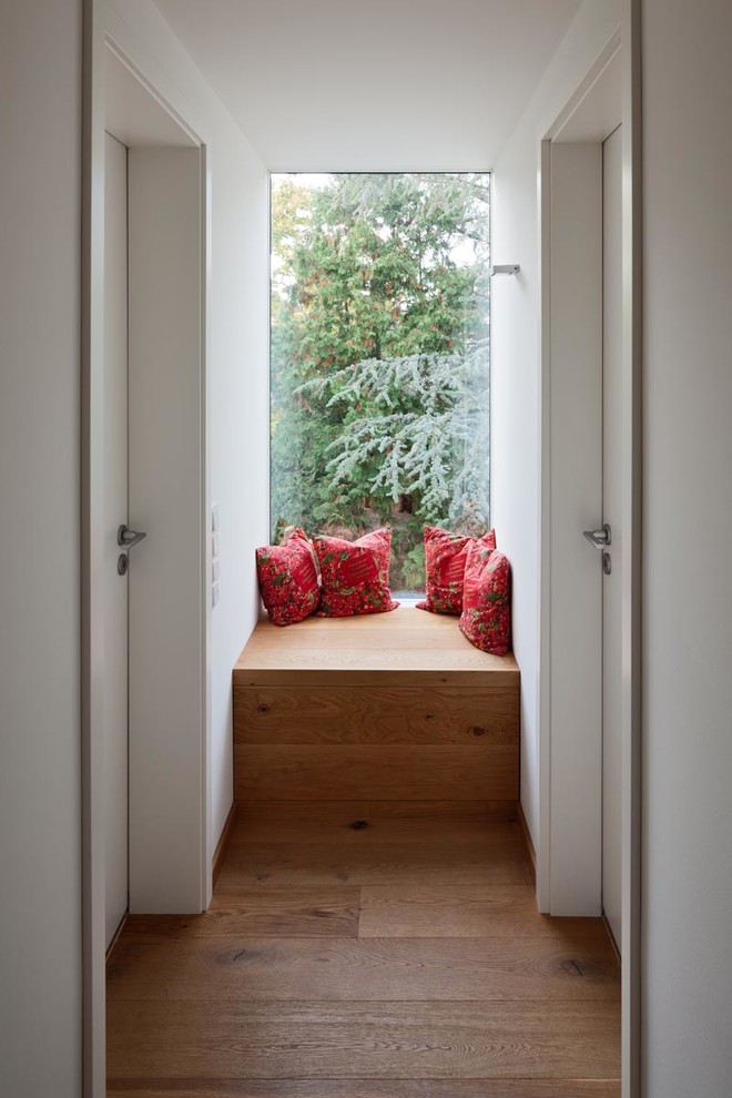 Immagine di un piccolo ingresso o corridoio design con pareti bianche e pavimento in legno massello medio