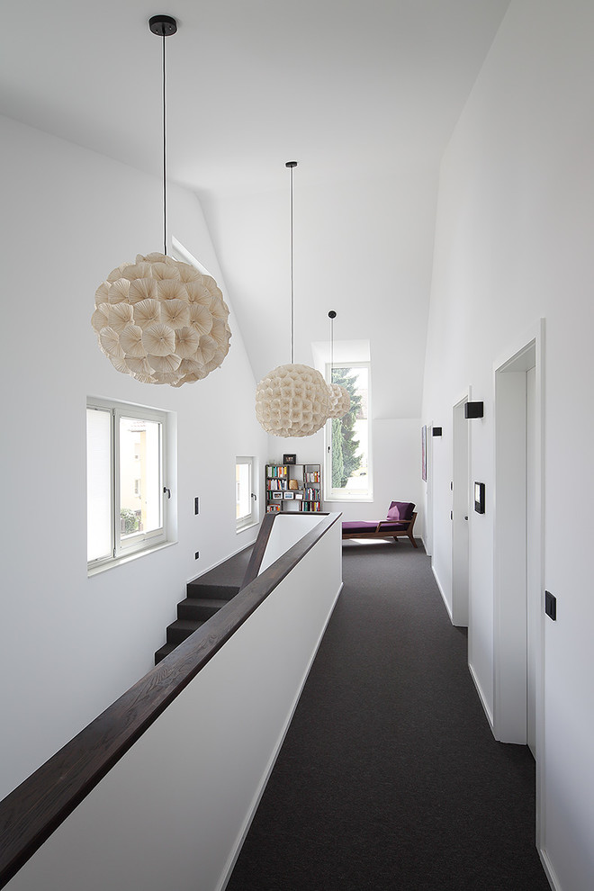 Mittelgroßer Moderner Flur mit weißer Wandfarbe, Teppichboden und schwarzem Boden in Stuttgart