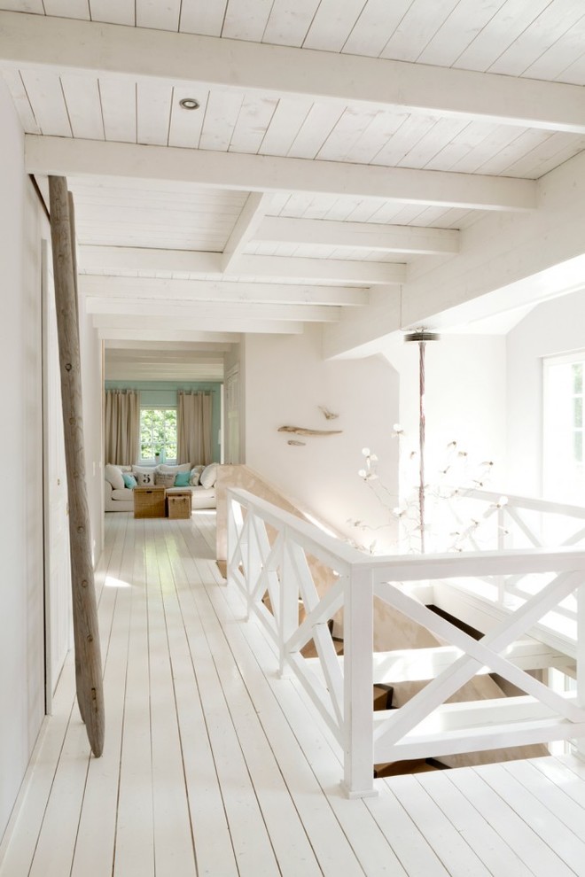 На фото: большой коридор в морском стиле с белыми стенами и деревянным полом