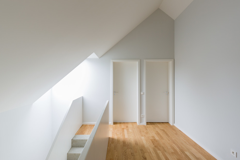 Mittelgroßer Moderner Flur mit weißer Wandfarbe, hellem Holzboden und braunem Boden in Leipzig