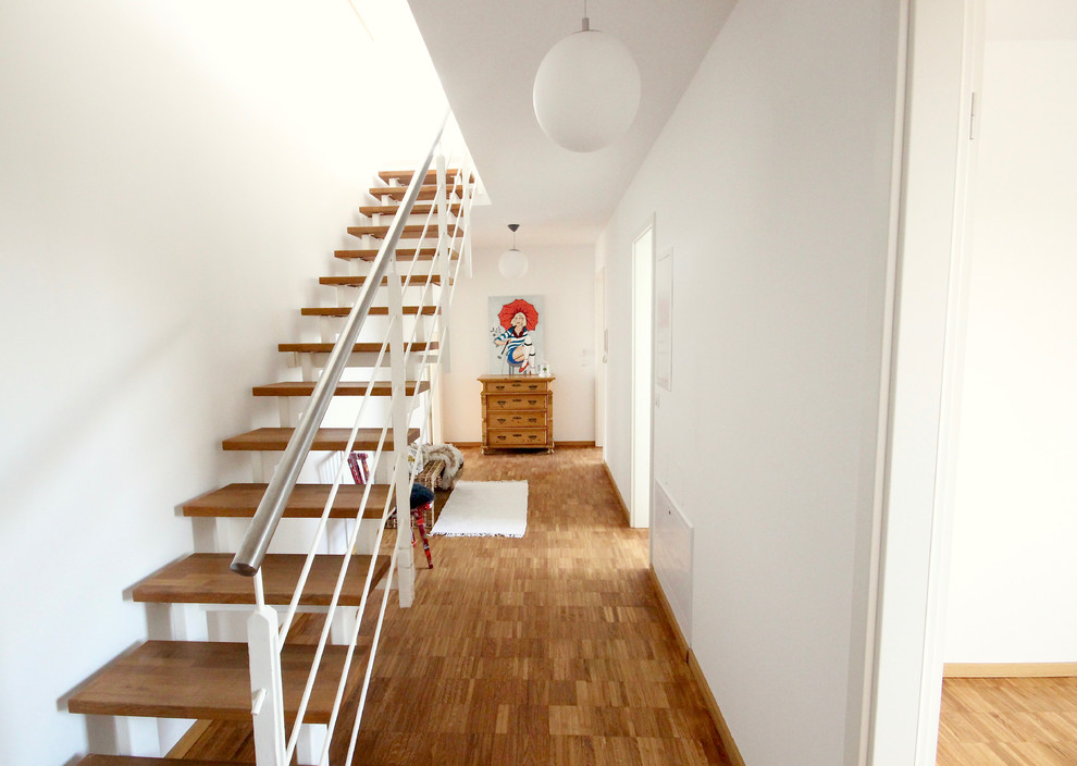 Mittelgroßer Moderner Flur mit weißer Wandfarbe, braunem Holzboden und braunem Boden in Frankfurt am Main